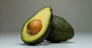 close up one whole and one cut in half avocado