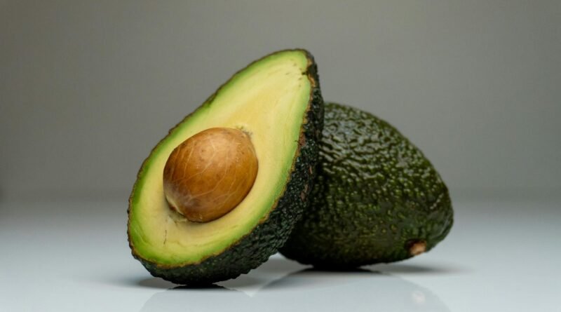 close up one whole and one cut in half avocado