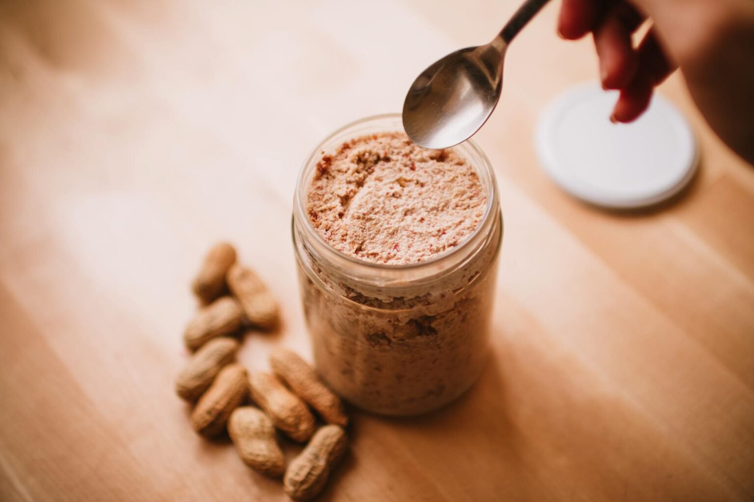 teaspoon over peanut butter in glass jar