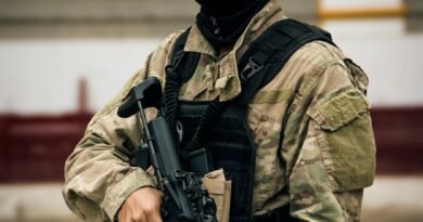 tactical soldier in camo gear holding rifle