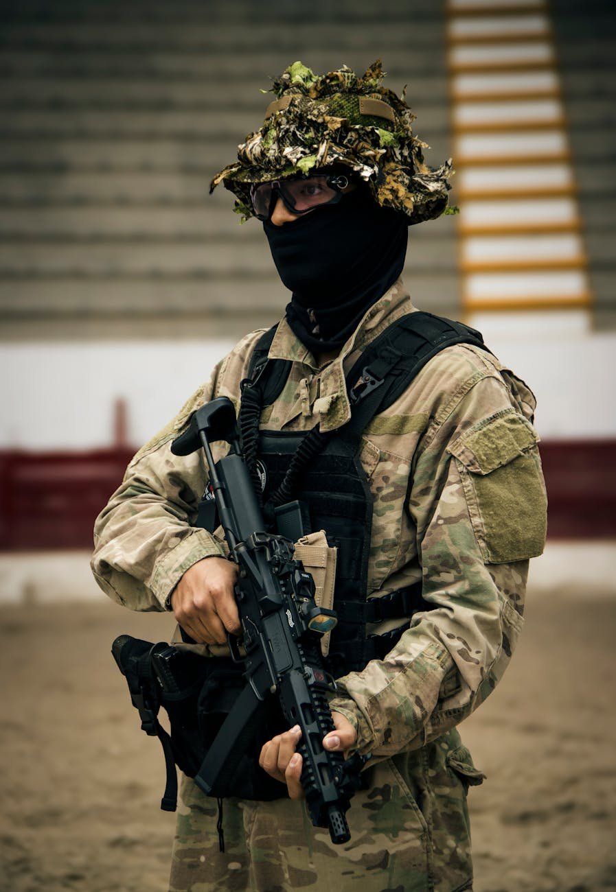 tactical soldier in camo gear holding rifle