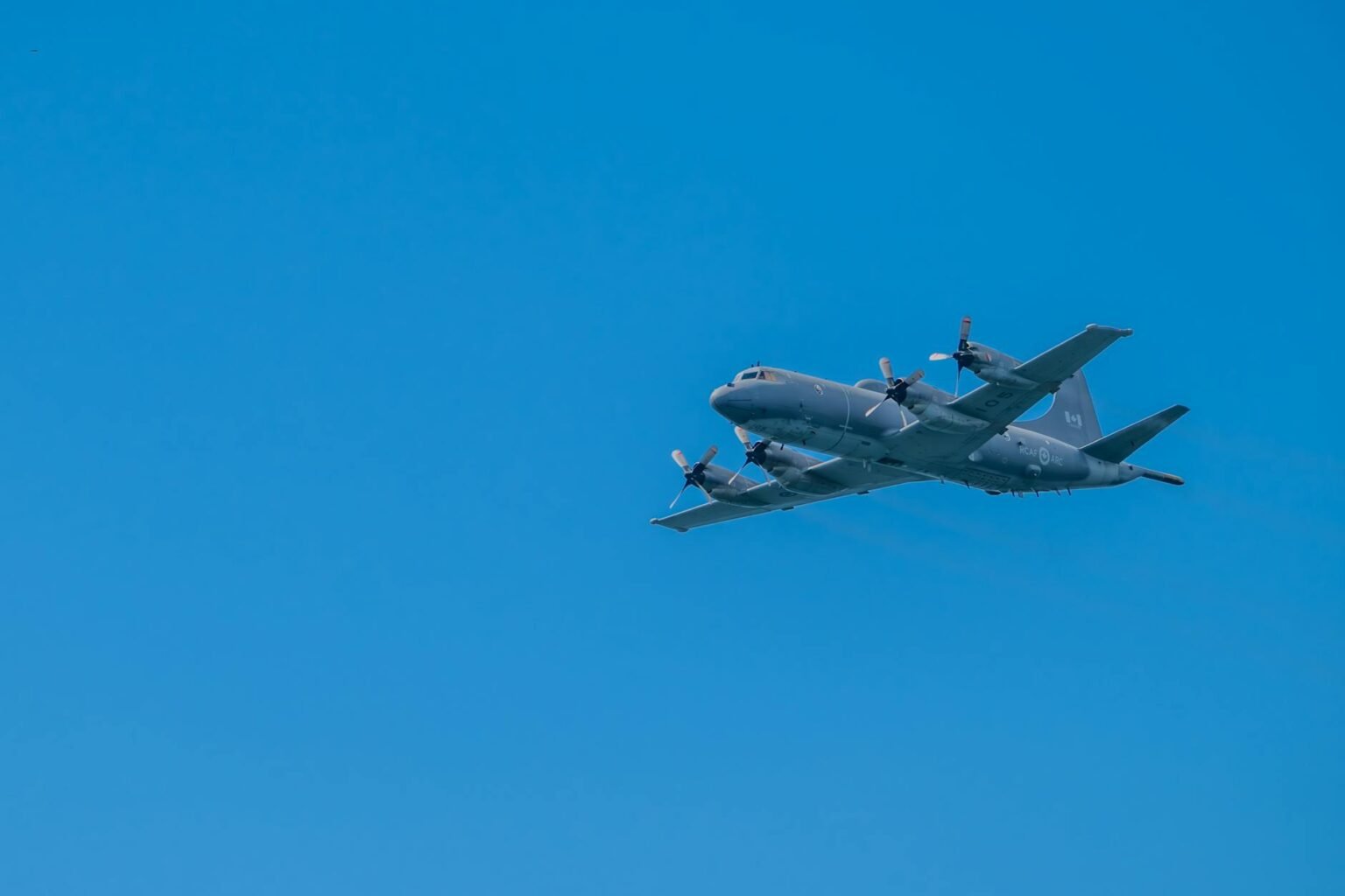 military aircraft flying in clear blue sky