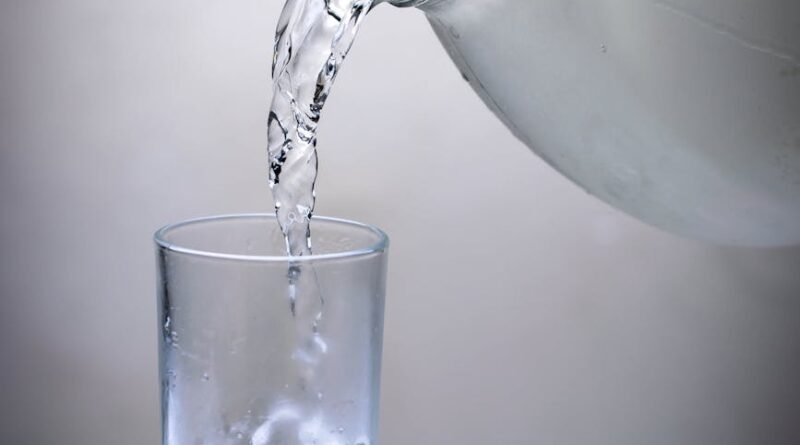 clear glass pitcher pouring water on clear drinking glass