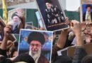 crowd holding iranian leadership posters in protest