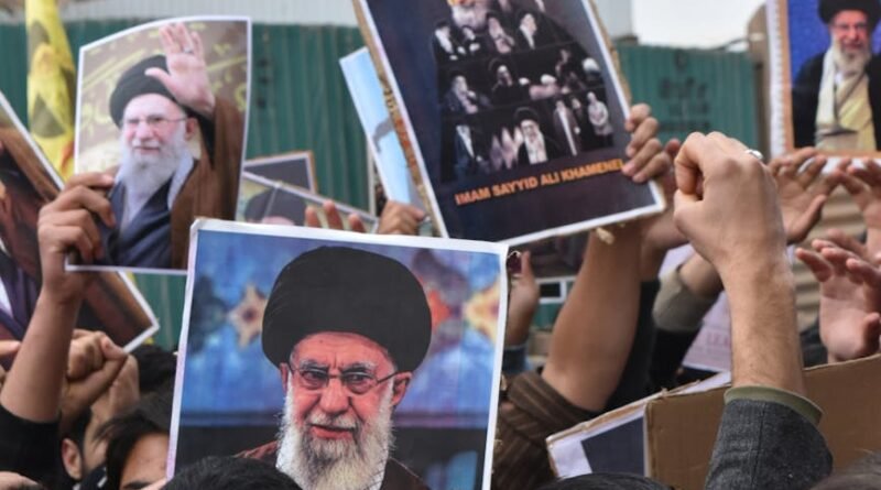 crowd holding iranian leadership posters in protest