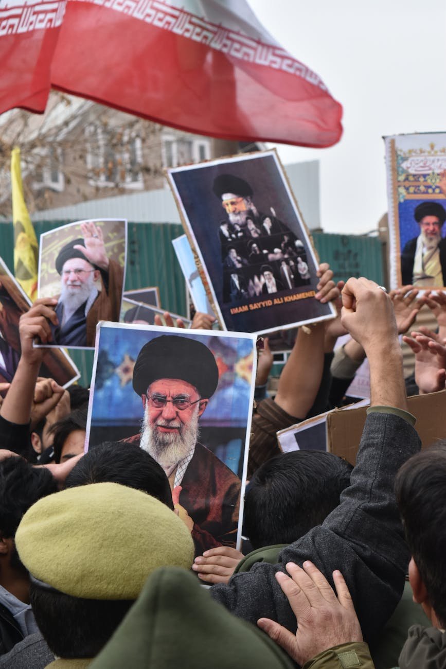 crowd holding iranian leadership posters in protest