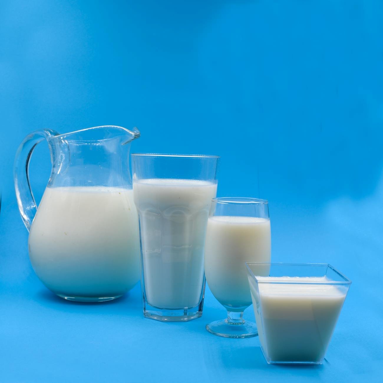 glasses of milk on a blue surface