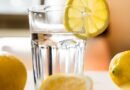 glass of cold water with lemon placed on table