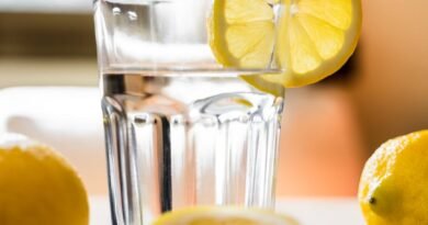 glass of cold water with lemon placed on table