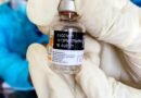 healthcare worker holding vaccine bottle close up