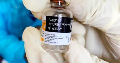 healthcare worker holding vaccine bottle close up
