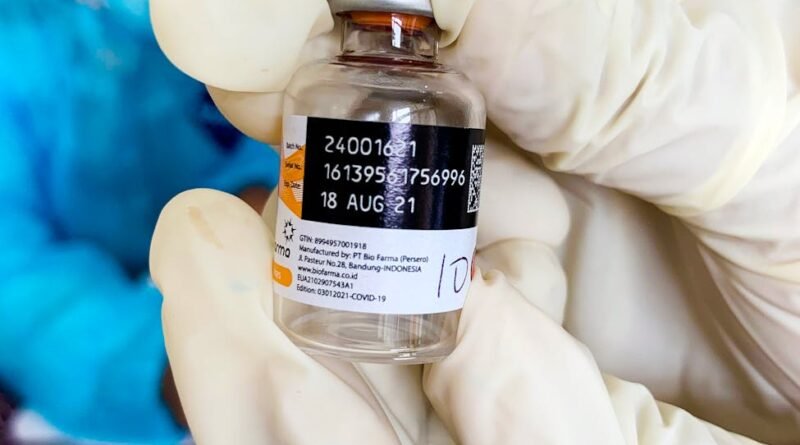 healthcare worker holding vaccine bottle close up