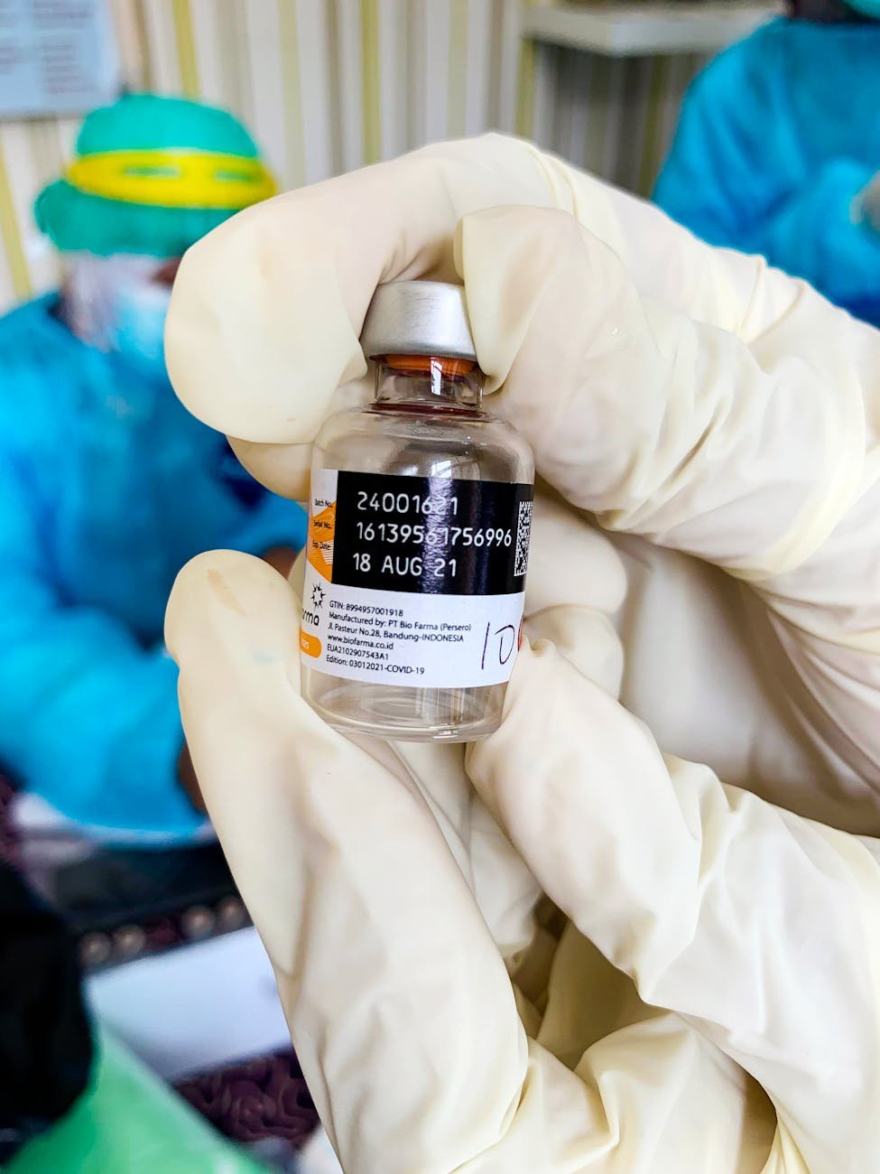 healthcare worker holding vaccine bottle close up