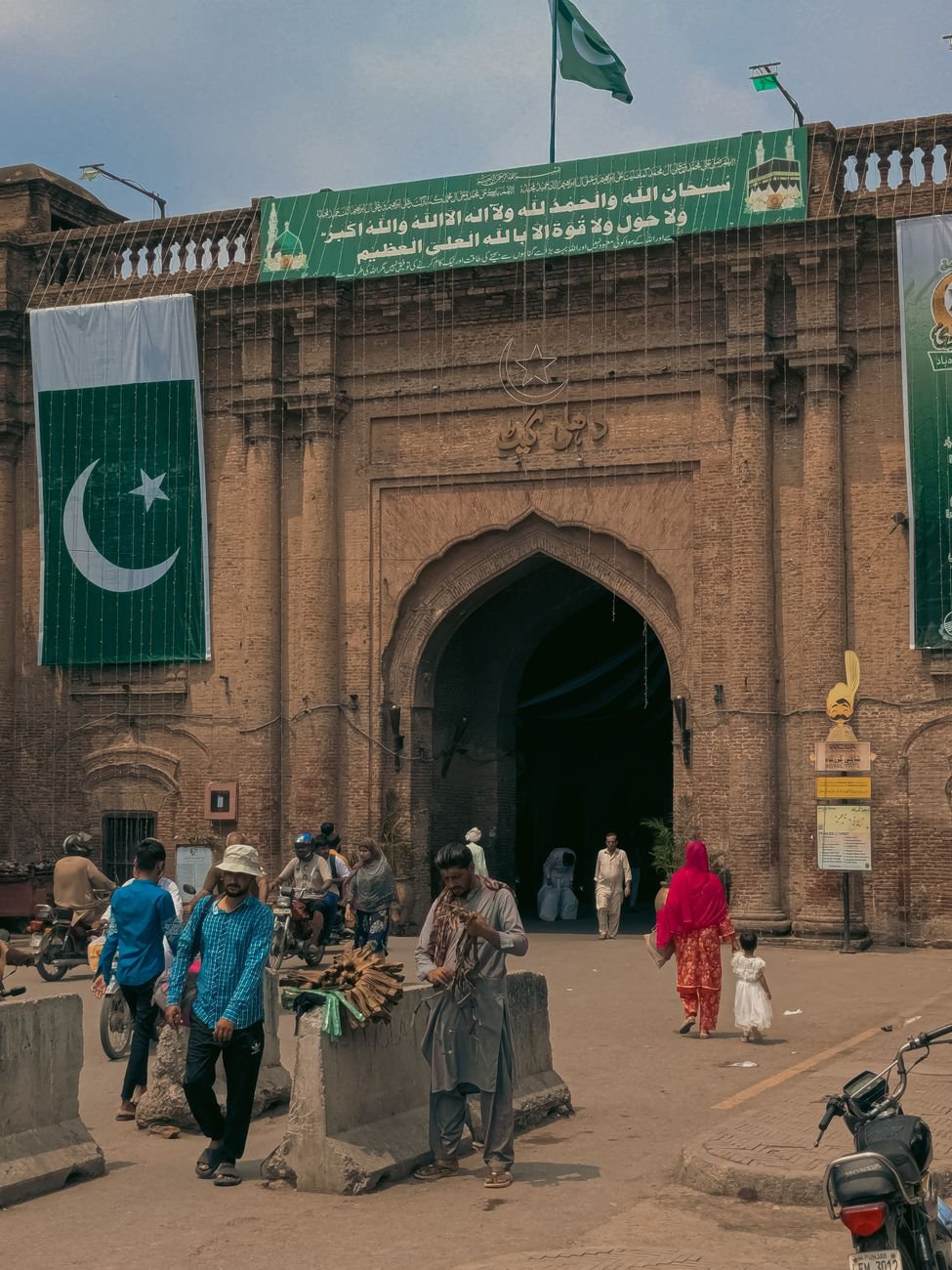 lahore fort entrance with national flags and visitors