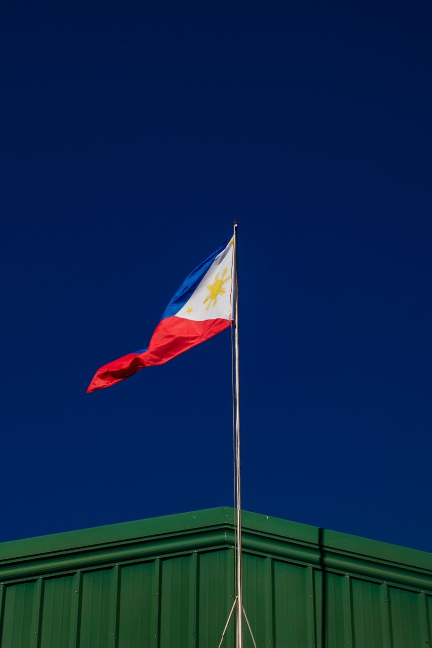 flag on flagpole against cloudless sky