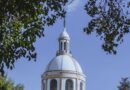 a dome of a building seen from between the trees