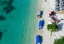 aerial view of tropical beach with boats and umbrellas
